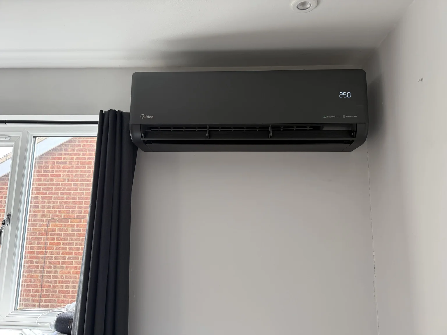 Black indoor air conditioning unit near a window