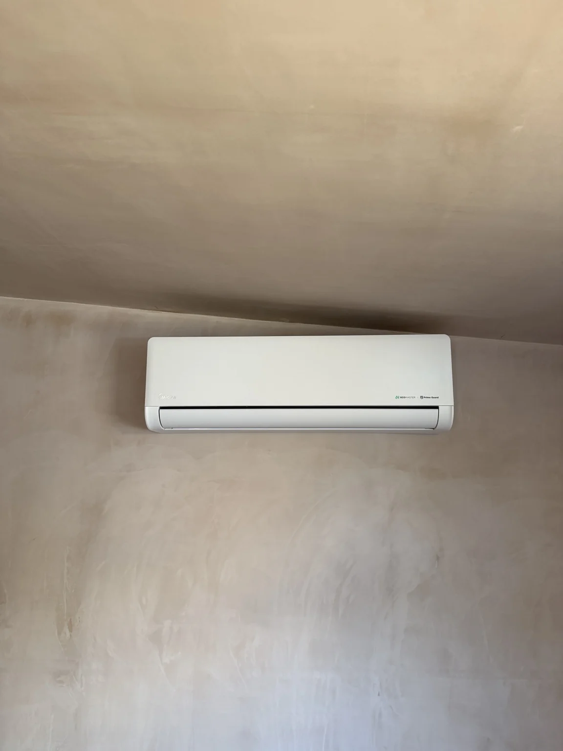 White air conditioning unit installed on a plain wall